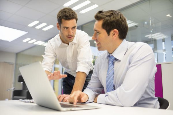 two men consulting with a laptop