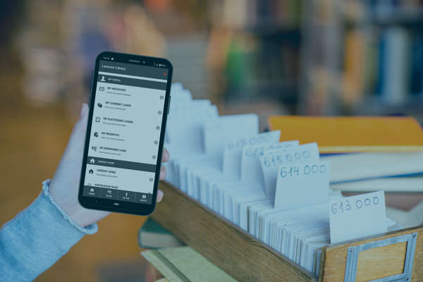 hand holding a mobile phone in a library